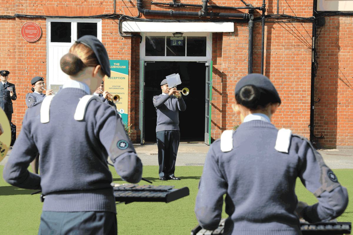 Cadets playing cornets outside the Brooklands clubhouse while a cadet plays a solo in the doorway